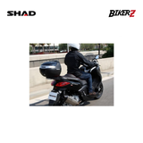 Person sitting on a black SHAD scooter with 'Bikerz' branding in the background